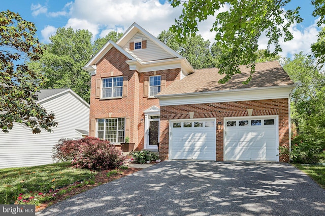 traditional home with driveway, a garage, and brick siding
