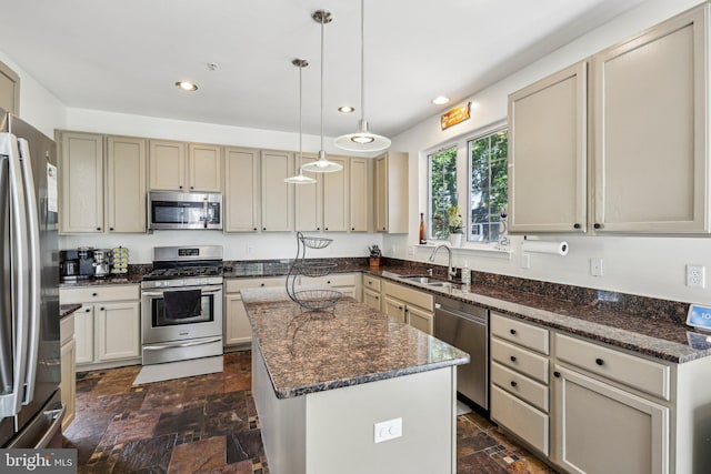 kitchen with stainless steel appliances, a sink, stone tile floors, a kitchen island, and recessed lighting
