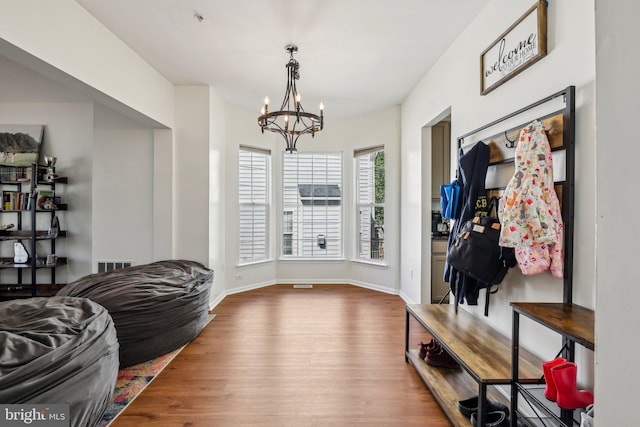 mudroom with a chandelier, wood finished floors, and baseboards