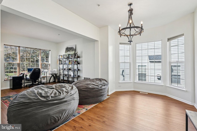 living area with a chandelier, an office area, wood finished floors, and baseboards