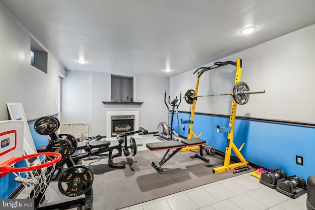 workout area with a fireplace and tile patterned flooring