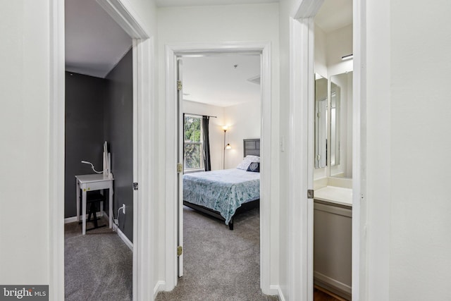 bedroom featuring carpet flooring, ensuite bath, and baseboards
