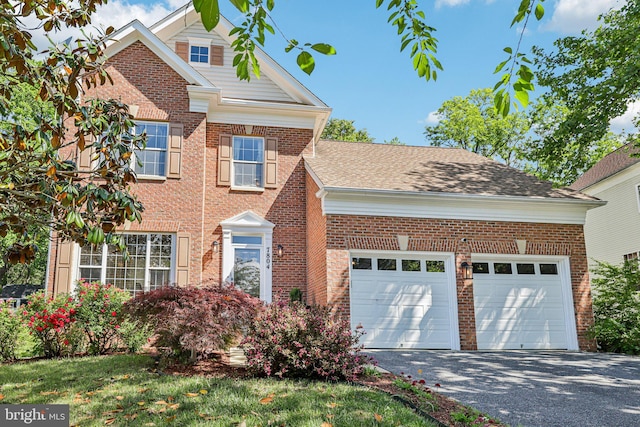 traditional-style home with brick siding, driveway, and an attached garage