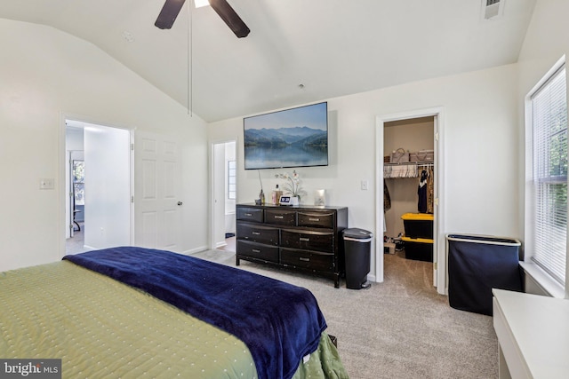 bedroom with lofted ceiling, carpet flooring, a walk in closet, multiple windows, and a closet