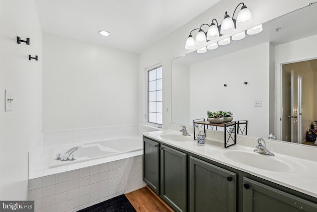 full bath featuring wood finished floors, a bath, and double vanity