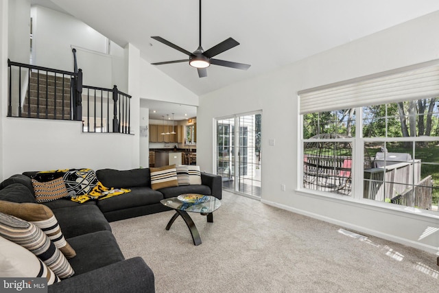 living area featuring carpet floors, a ceiling fan, baseboards, and high vaulted ceiling