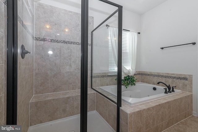 bathroom featuring a shower stall and a bath