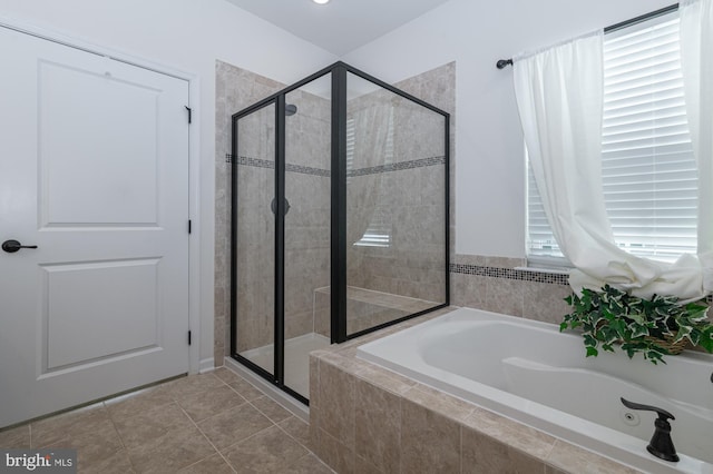bathroom featuring a stall shower, a bath, and tile patterned floors