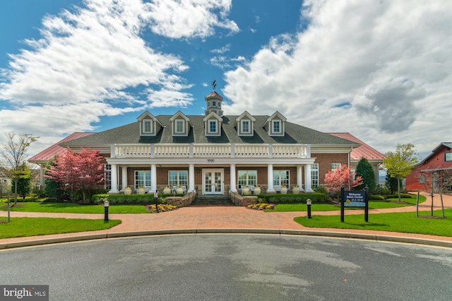 view of front of home with french doors, a front lawn, and brick siding