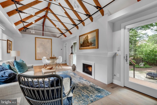16 Southgate Ave, Annapolis, MD 21401 - living area featuring wood finished floors, beam ceiling, high vaulted ceiling, a glass covered fireplace, and baseboards