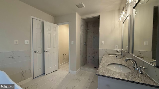 bathroom featuring marble look tile flooring, a shower stall, double vanity, and baseboards