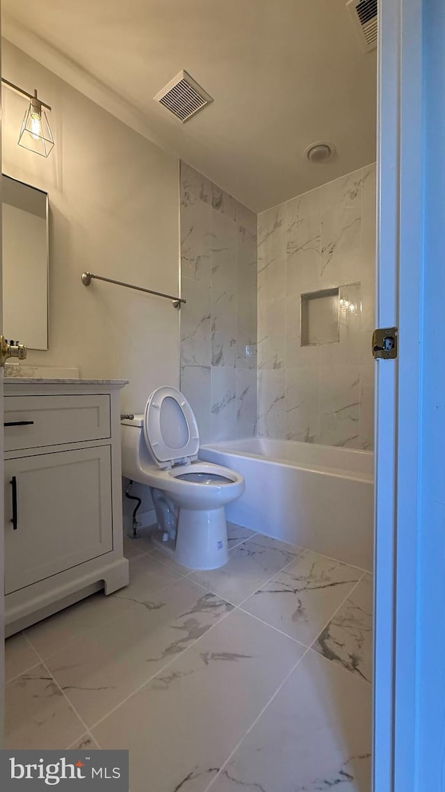 bathroom with marble look tiles, vanity, and toilet
