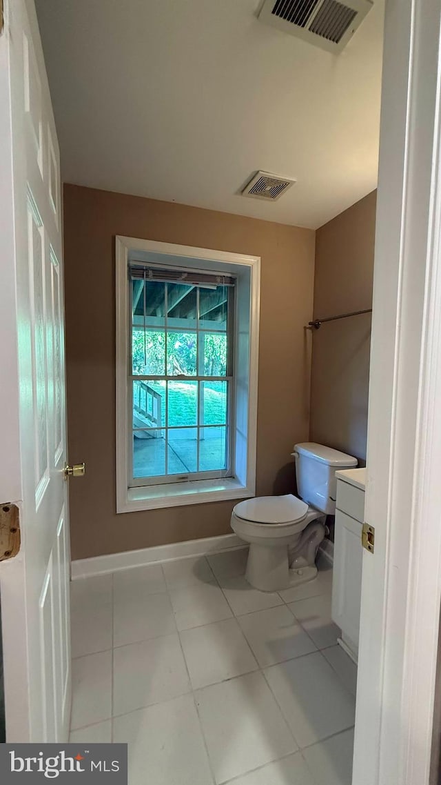 bathroom with toilet, tile patterned floors, and baseboards