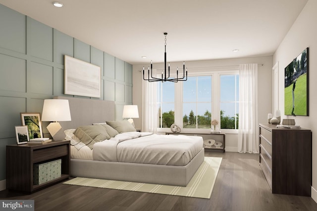 bedroom with a decorative wall, recessed lighting, wood finished floors, and a notable chandelier