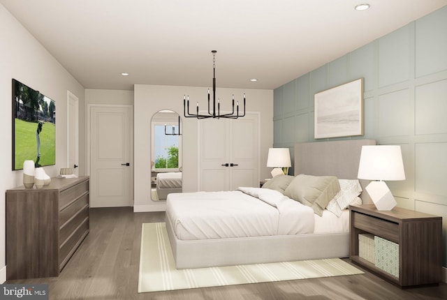 bedroom with recessed lighting, wood finished floors, and a chandelier