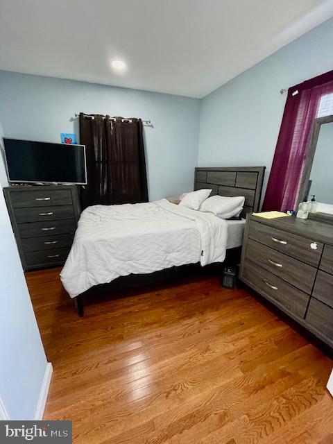 bedroom featuring baseboards, recessed lighting, and wood finished floors