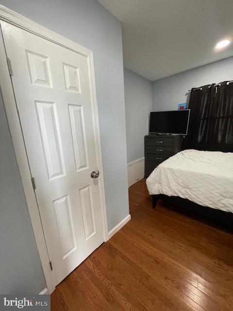 bedroom with baseboards and wood finished floors