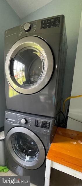 laundry area with laundry area and stacked washer / dryer