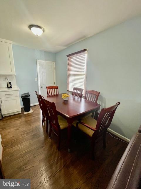 dining room with baseboards and dark wood finished floors