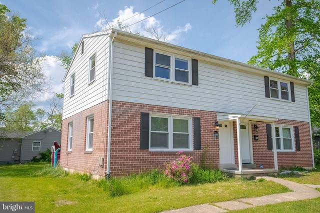 view of front of property featuring brick siding and a front lawn