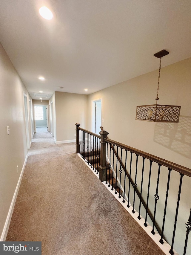 hall with attic access, baseboards, an upstairs landing, carpet, and recessed lighting