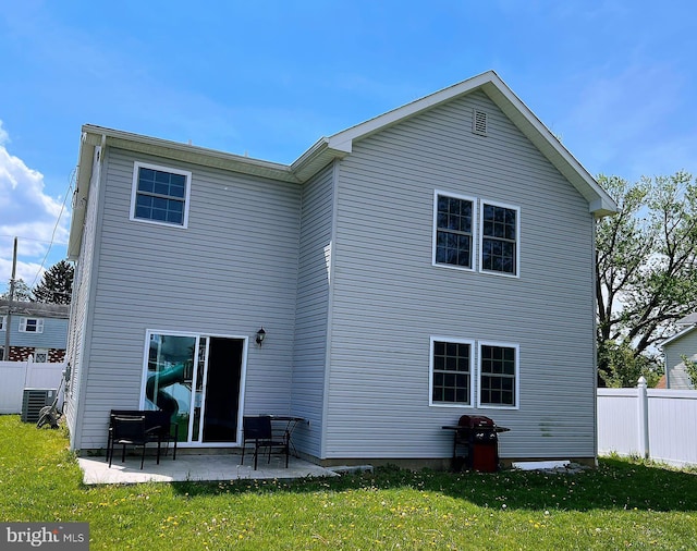 rear view of property with fence, a patio, a yard, and cooling unit