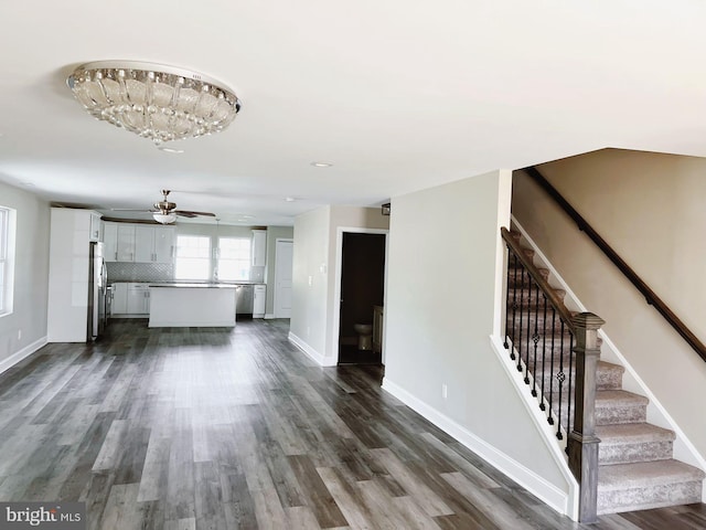 unfurnished living room with stairway and dark wood-style floors