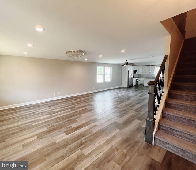 interior space featuring ceiling fan, stairs, recessed lighting, baseboards, and wood finished floors