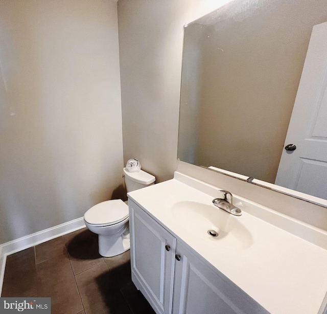 bathroom with vanity, tile patterned flooring, baseboards, and toilet
