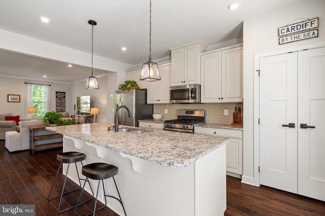 18095 Red Mulberry Rd, Dumfries, VA 22026 - kitchen with stainless steel appliances, a sink, dark wood finished floors, a kitchen breakfast bar, and backsplash