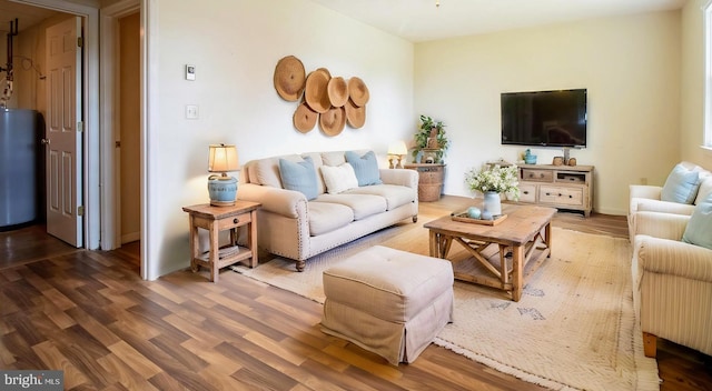 living area with water heater, wood finished floors, and baseboards