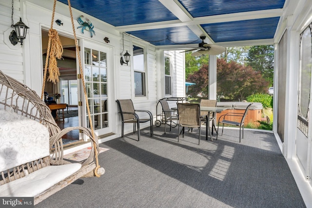 sunroom / solarium with a ceiling fan, outdoor dining space, and a hot tub