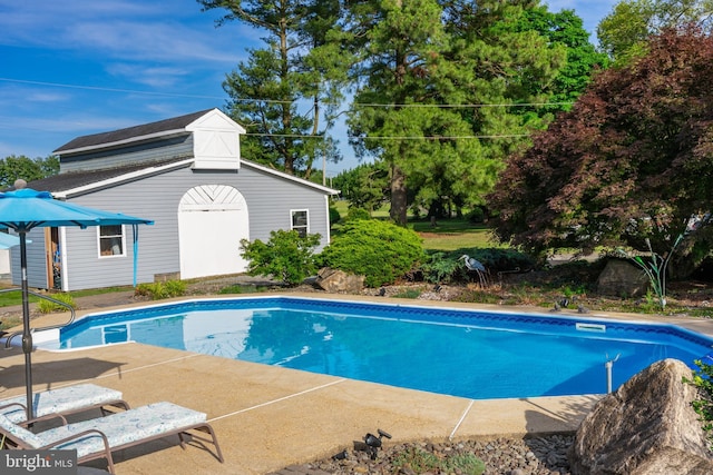 outdoor pool featuring an outbuilding
