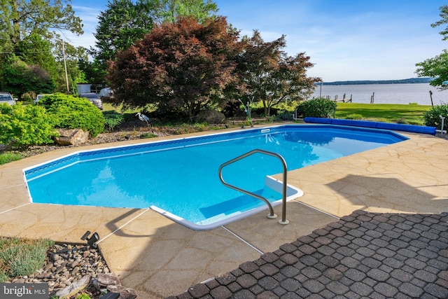 view of swimming pool with a water view, a covered pool, and a patio area