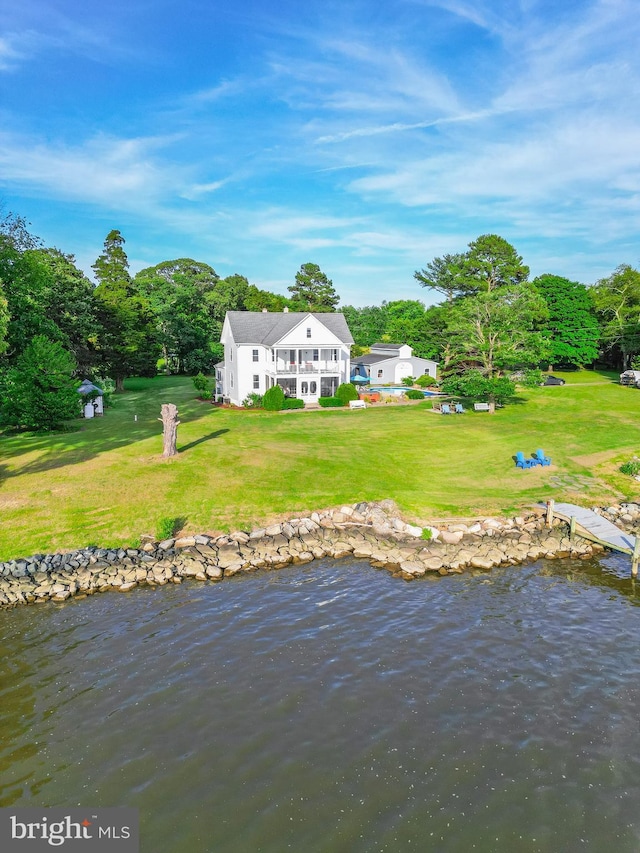 rear view of house featuring a lawn and a water view