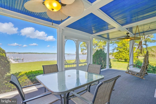 sunroom featuring outdoor dining area, a water view, and ceiling fan
