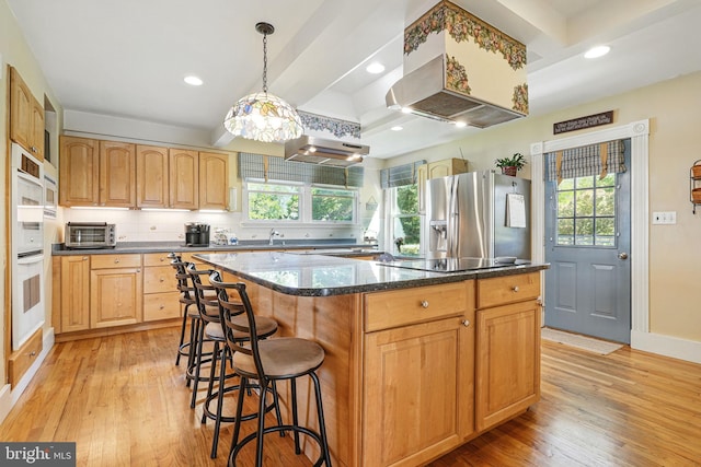 kitchen featuring a wealth of natural light, light wood-style flooring, and stainless steel fridge with ice dispenser