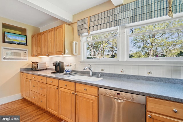 kitchen featuring stainless steel dishwasher, a sink, baseboards, white microwave, and light wood-style floors