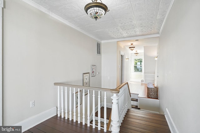 stairway featuring visible vents, baseboards, an ornate ceiling, ornamental molding, and hardwood / wood-style floors