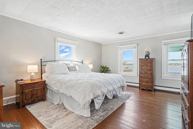 bedroom with ornamental molding, baseboard heating, and hardwood / wood-style flooring
