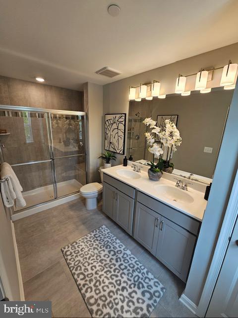 7304 Roxy Run, Clinton, MD 20735 - full bathroom with double vanity, visible vents, a shower stall, and a sink