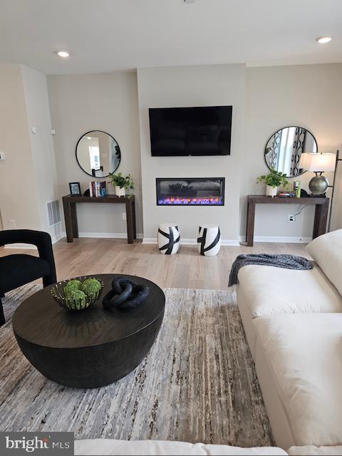 7304 Roxy Run, Clinton, MD 20735 - living room featuring recessed lighting, baseboards, a glass covered fireplace, and wood finished floors