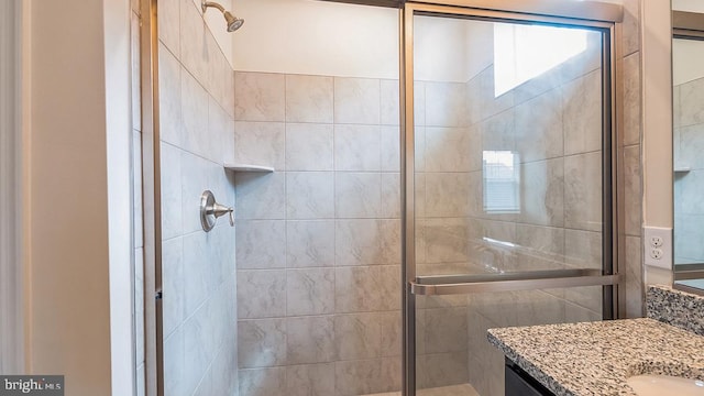 full bathroom featuring plenty of natural light, a shower stall, and vanity