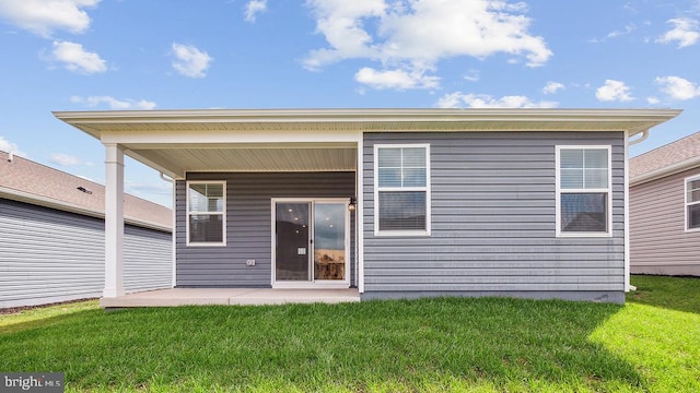 rear view of house with a patio and a yard