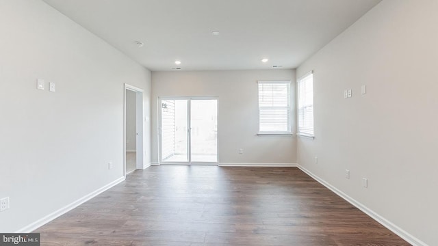 unfurnished room featuring dark wood-type flooring, recessed lighting, and baseboards