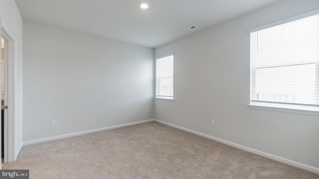 spare room with baseboards, carpet, and visible vents