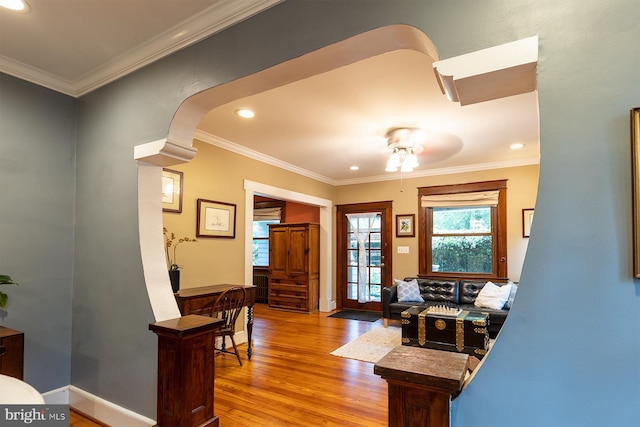 living room featuring wood finished floors, recessed lighting, crown molding, a ceiling fan, and baseboards
