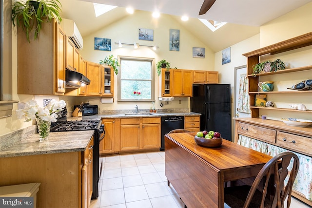 kitchen with a sink, a skylight, black appliances, under cabinet range hood, and a wall unit AC