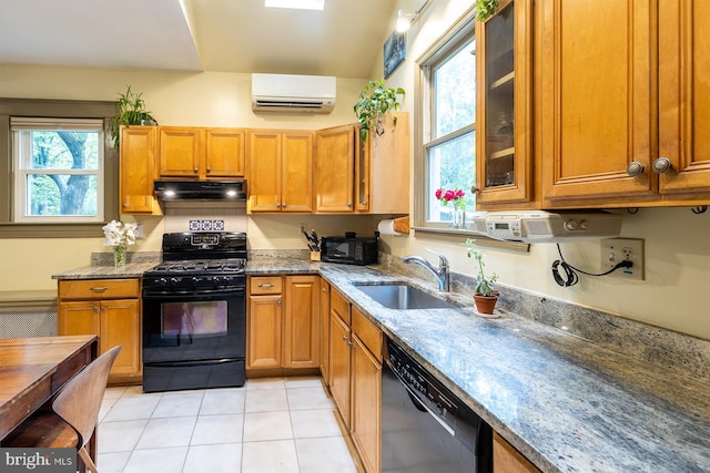 kitchen featuring a sink, black appliances, under cabinet range hood, light stone counters, and an AC wall unit