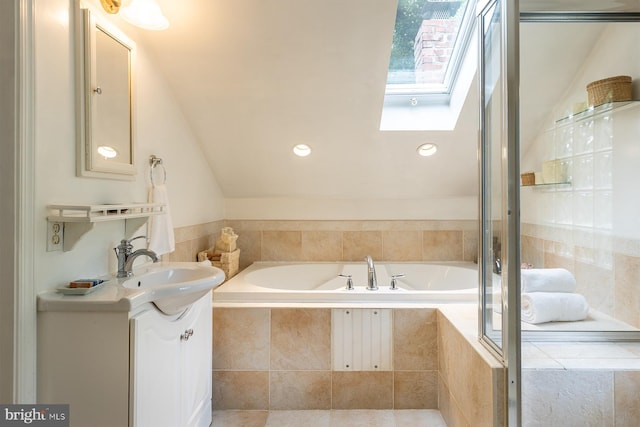 bathroom featuring a garden tub, vanity, lofted ceiling with skylight, and a shower with shower door